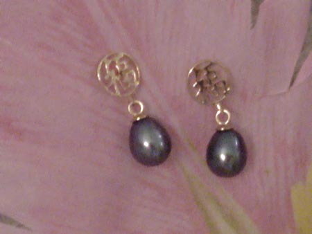 6.5mm by 8.5mm oval black pearl earrings dangling from a 14K gold circle.