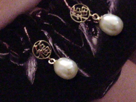 7.5mm by 9mm oval white pearl earrings dangling from a 14K gold circle.