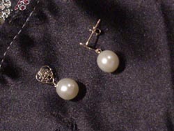 [ 7.5mm by 9mm oval white pearl earrings dangling from a 14K gold heart. ]